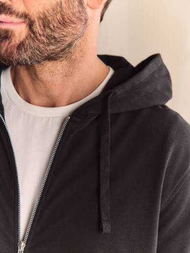 Zip-up hoodie manufacturer inspecting zipper alignment and premium hoodie quality
